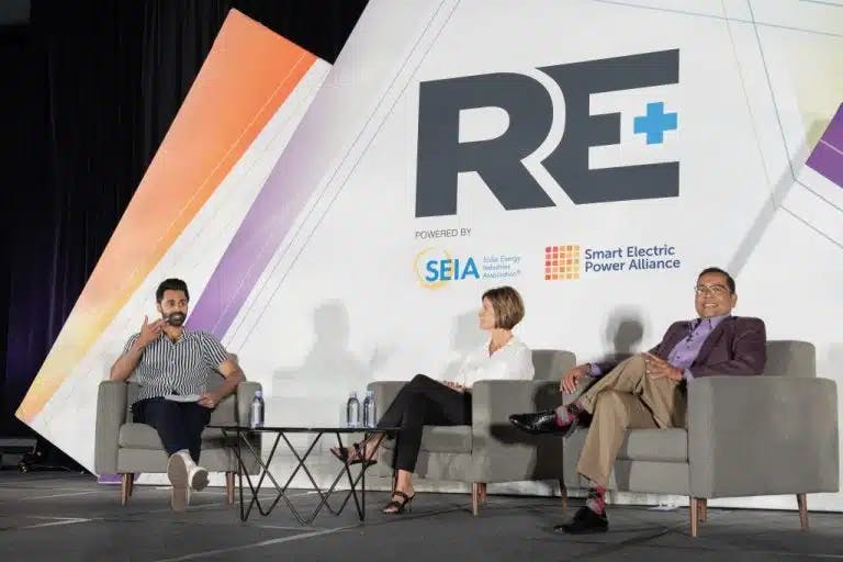 Panelists speaking together at the RE+ conference.