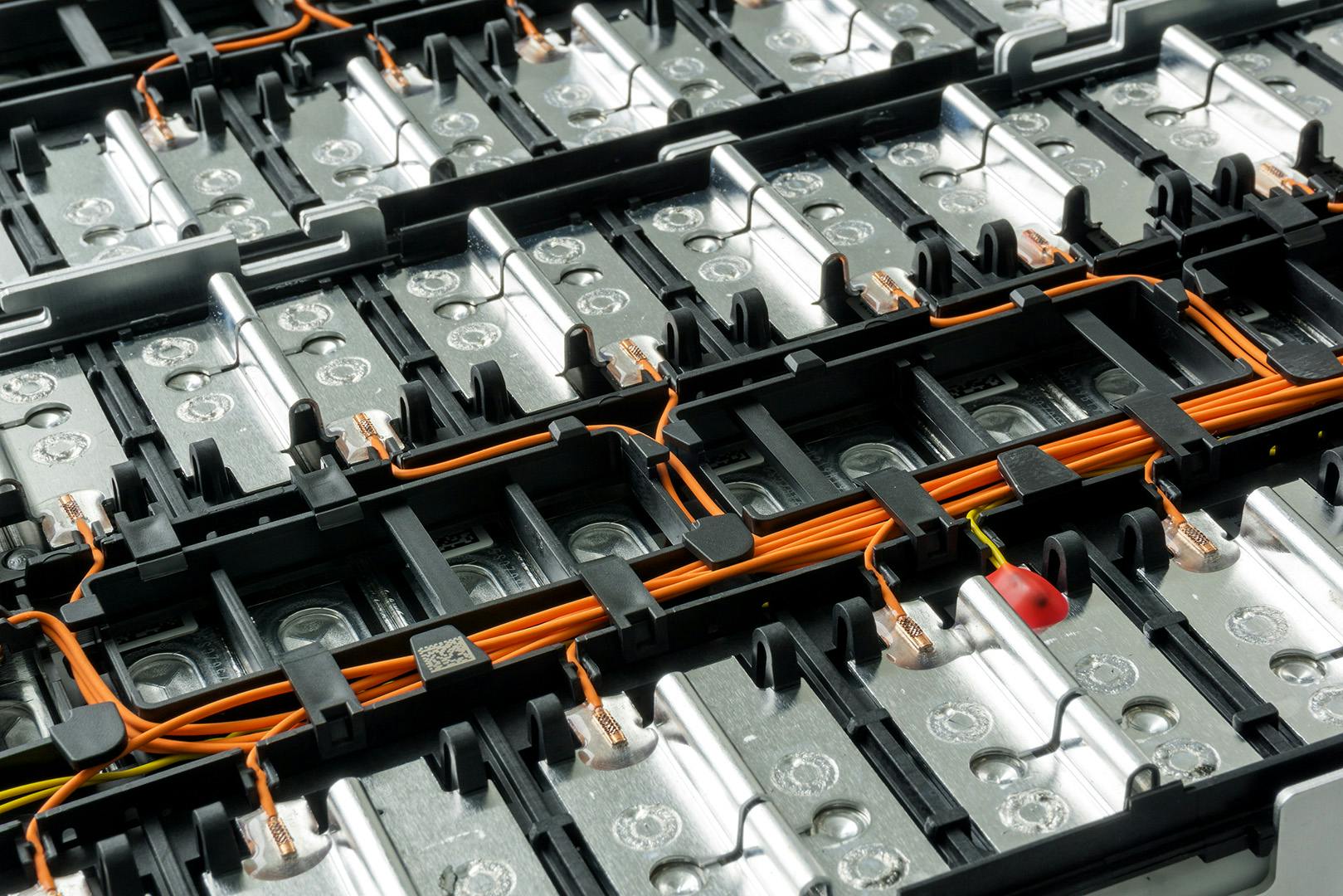 Close up image of a battery with exposed orange wires