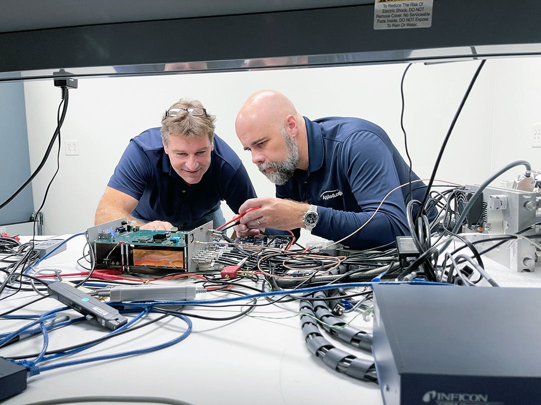 Two male engineers working with wiring on an engineering project at AppliedLogix