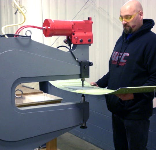 Engineer cutting aerospace equipment for assembly