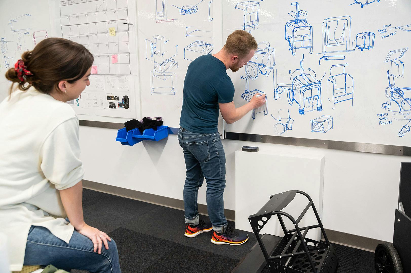 Industrial Designers sketching ideas on a white board