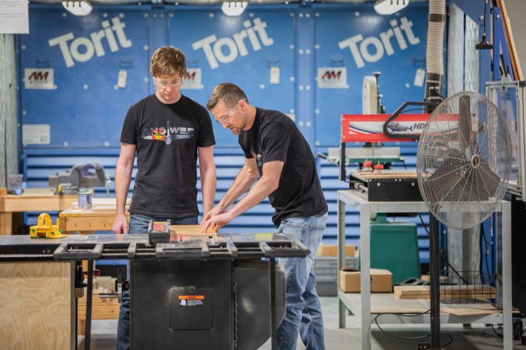 Two engineers working on a part.