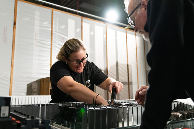 Employees working together on machine